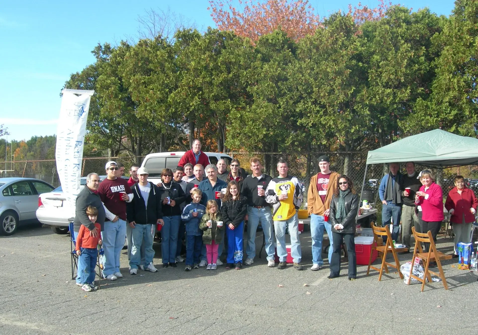 A group of people standing in front of trees.